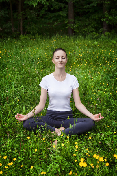Jeune fille pratiquant le yoga dans une forêt
 - Photo, image