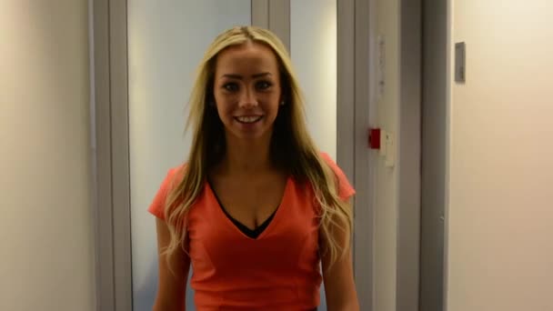 giovane donna attraente cammina e sorride alla macchina fotografica in ufficio (hall) - steadicam
 - Filmati, video