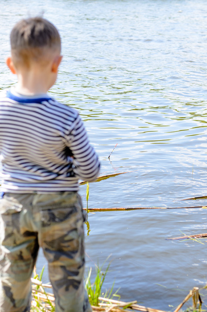 Niño macho en la orilla del río preparándose para la pesca
 - Foto, Imagen