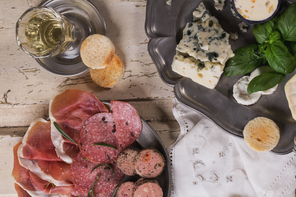 eine Reihe verschiedener französischer und italienischer Käse- und Fleischsorten auf dem Wein - Foto, Bild