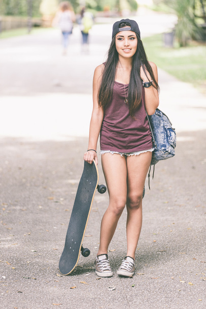 Portrait of a beautiful skater girl at park. - Foto, afbeelding