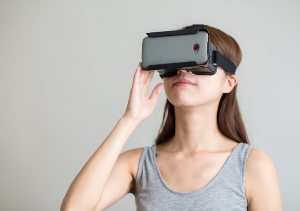 Mujer sosteniendo dispositivo de realidad virtual
 - Foto, Imagen