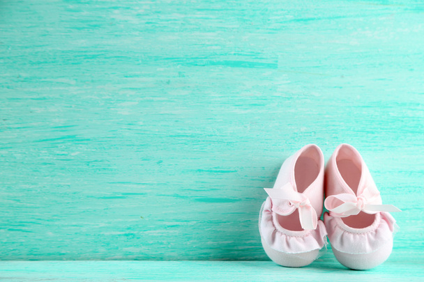 Pink toddler shoes on wooden background - Fotó, kép