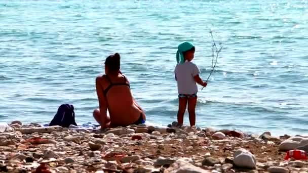 Na wybrzeżu Morza Adriatyckiego. Mama i dziecko są odpoczynku nad wodą.  - Materiał filmowy, wideo