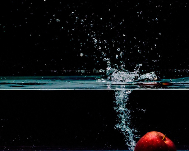 Mela rossa spruzzata in acqua, isolata su fondo nero
 - Foto, immagini