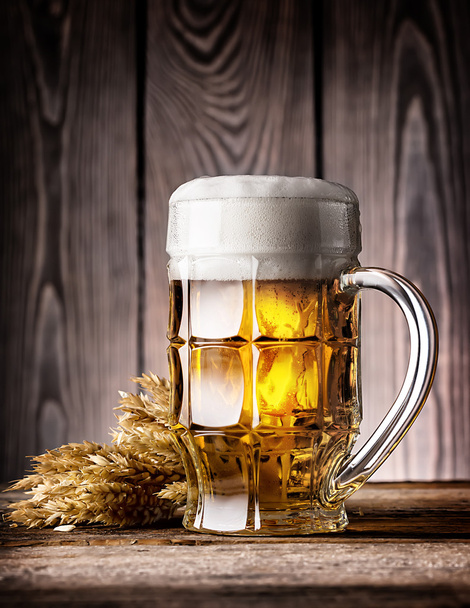 Taza facetada de cerveza ligera con espuma y orejas
 - Foto, Imagen