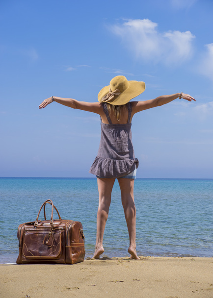 Woman with leather travel bag on the beach - Фото, изображение