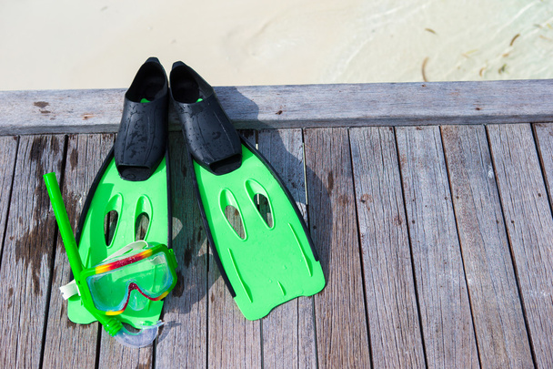 Mascarilla, snorkel y aletas para snorkel en embarcadero de madera
 - Foto, imagen