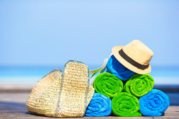 Pláž a letní prázdniny příslušenství koncept - detailní barevné ručníky, klobouk, pytel a opalovací krém - Fotografie, Obrázek