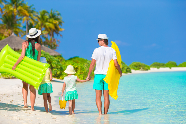 Mooie en gelukkige familie op witte strand met air matrassen - Foto, afbeelding