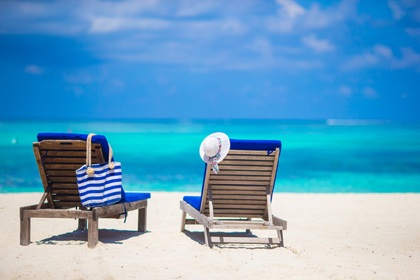 Sillas de salón con bolsa y sombrero en la playa tropical blanca
 - Foto, imagen