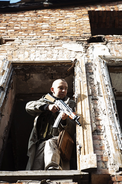 De skinhead kijkt uit het raam met het pistool - Foto, afbeelding