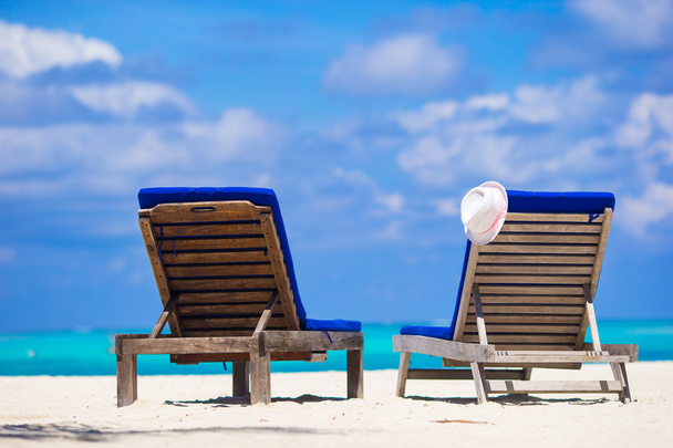 Ξαπλώστρες με καπέλο σε τροπική παραλία με λευκή - Φωτογραφία, εικόνα