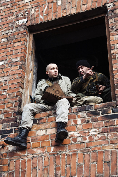 Dos hombres tomando el resto mientras estaban escondidos en el viejo edificio en ruinas
 - Foto, imagen