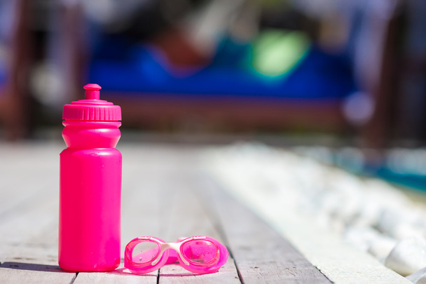 Pink sporty water bottle near swimming pool - Fotó, kép