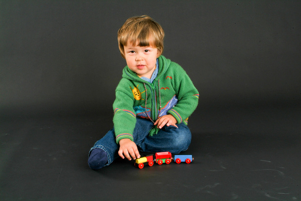 Young boy posing with a colorful toy train - Photo, image