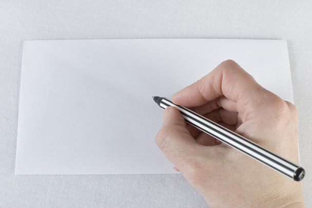 ženská ruka drží pero a psaní na obálce bílém - Fotografie, Obrázek
