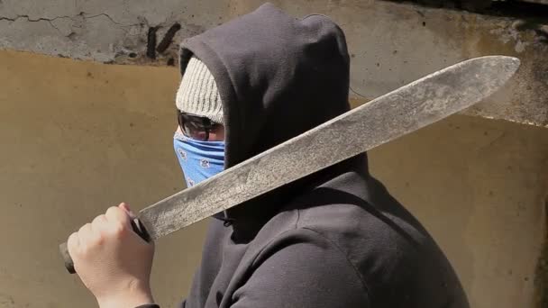 Mies, jolla on machete olkapäällä
 - Materiaali, video