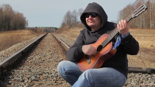 Hombre tocando la guitarra en el ferrocarril
 - Imágenes, Vídeo