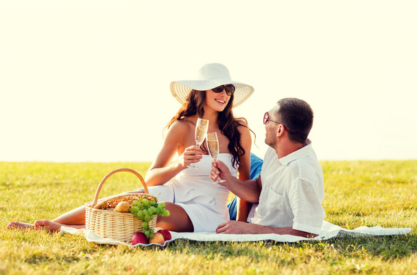 smiling couple drinking champagne on picnic - 写真・画像