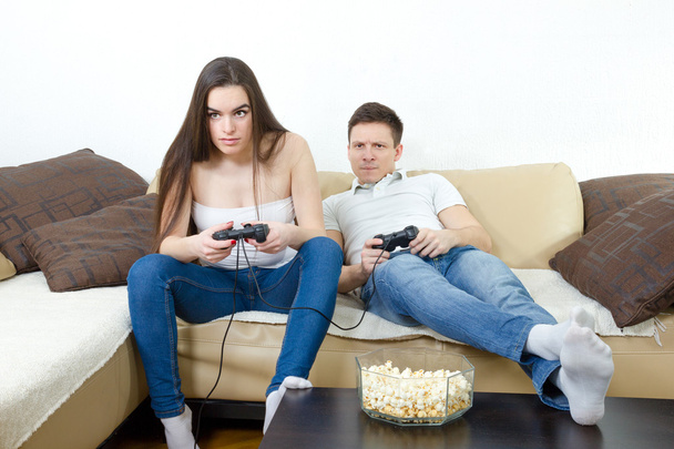  Koppel zit in de woonkamer en videospelletjes spelen op console o - Foto, afbeelding