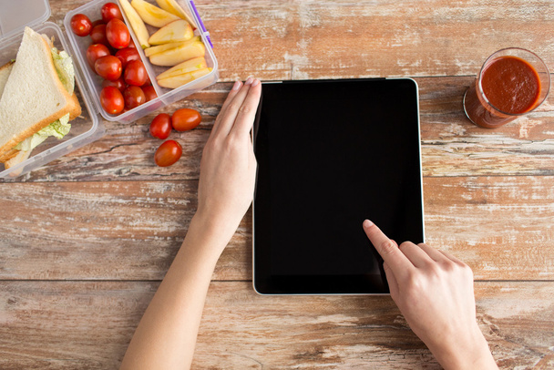 close up of woman with tablet pc food on table - Foto, Imagem