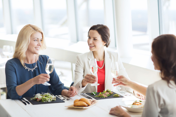 happy women drinking champagne at restaurant - Photo, image