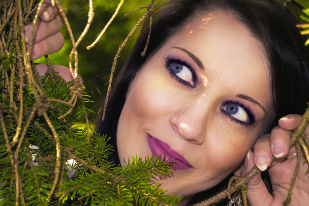 hübsche Frau versteckt sich hinter Bäumen - Foto, Bild