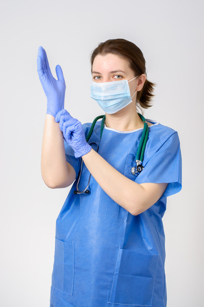 Arts zetten blauwe chirurgische handschoenen - Foto, afbeelding