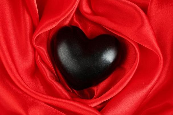 czarny serce na tkanina tło - Zdjęcie, obraz