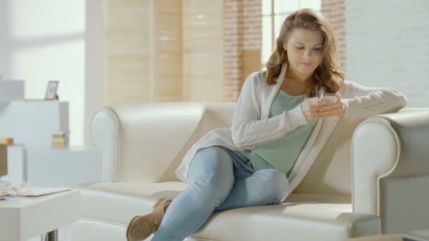 Happy young smiling female chatting with boyfriend on smartphone - Materiał filmowy, wideo
