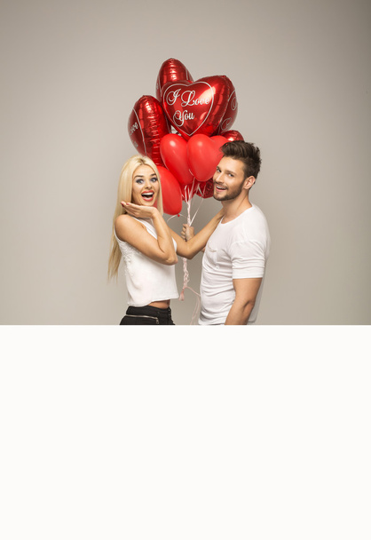 Attractive couple with red balloons - Φωτογραφία, εικόνα