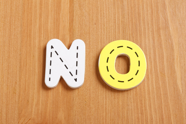 NO, spell by woody puzzle letters with woody background - Foto, imagen