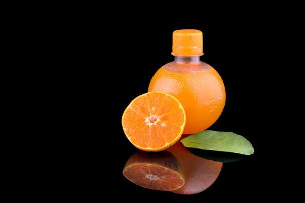 Jugo de naranja en una botella con fruta de naranja madura
 - Foto, Imagen