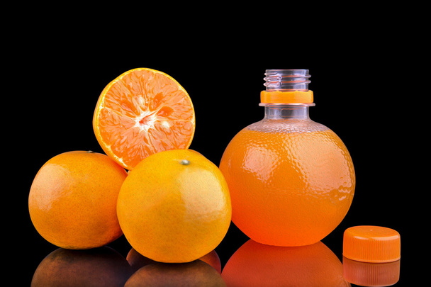 láhev pomerančové šťávy a zralé pomeranče - Fotografie, Obrázek