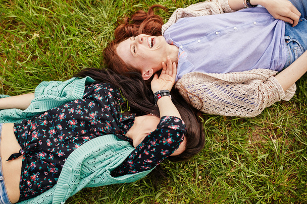 Two cheerful sisters lying on the grass - Foto, Imagem