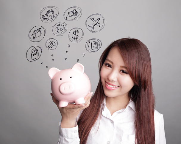 woman holding pink piggy bank - 写真・画像