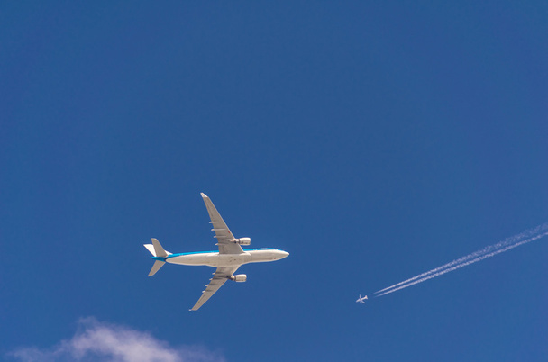 Two airplanes in the sky crossing paths at different flight trav - Photo, Image