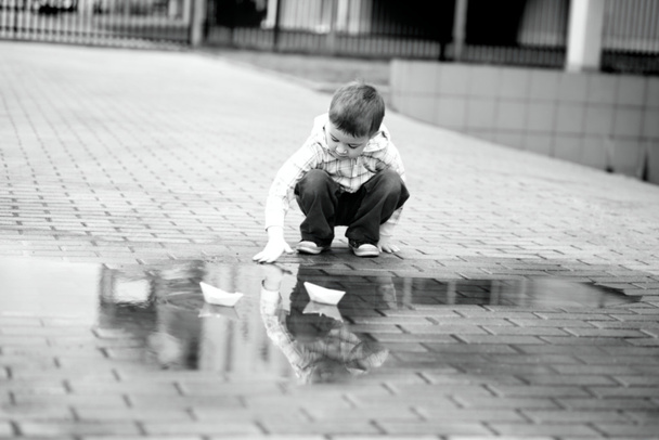 Хлопчик грає з паперовим човном
 - Фото, зображення