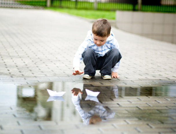 Junge spielt mit Papierboot - Foto, Bild
