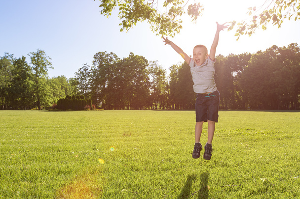 happy little boy laying on the grass - 写真・画像
