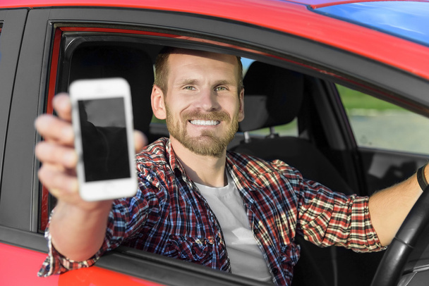 Człowiek w samochodzie jazdy Wyświetlono inteligentny telefon. - Zdjęcie, obraz
