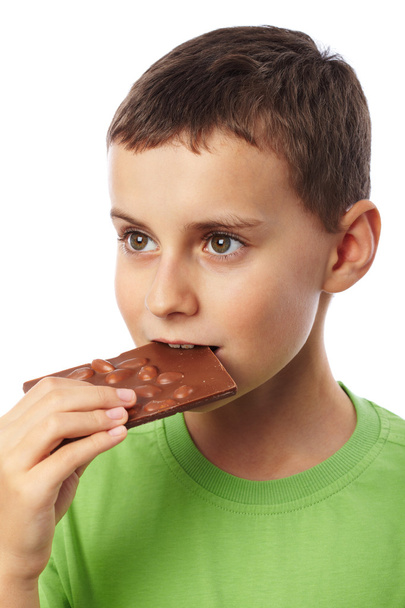 Boy eating chocolate with almonds - Fotoğraf, Görsel