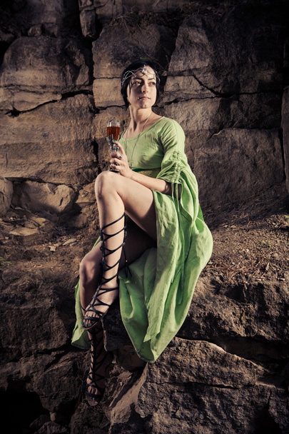 Прекрасна принцеса ельфів п'є вино на скелі
. - Фото, зображення