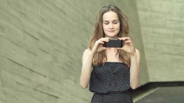 Hermosa chica modelo chica viendo foto de vídeo en el teléfono móvil
 - Imágenes, Vídeo