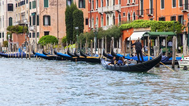 VENICE, ITALY - on APRIL 29, 2015. The gondola with passengers floats on the Grand channel (Canal Grande). The grand channel is the main transport artery of Venice and its most known channel - 写真・画像