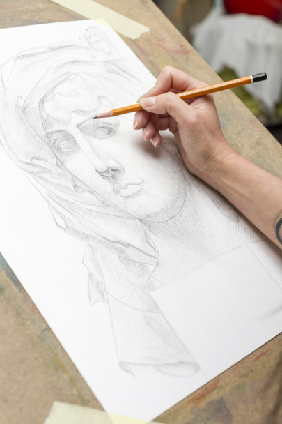 Fiatal művész fest egy ceruza portréja. - Fotó, kép