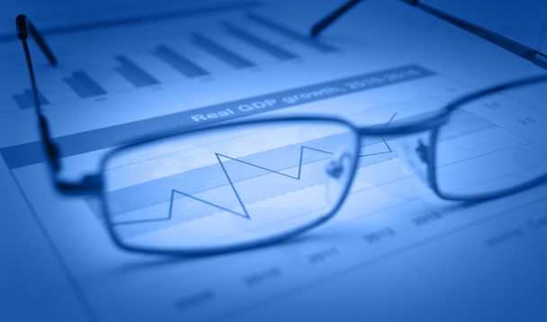 Glasses on blue financial chart and graph, success concept - Photo, Image