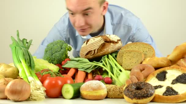 hombre huele a comida - verduras, frutas y productos de panadería - estudio de fondo blanco
 - Imágenes, Vídeo