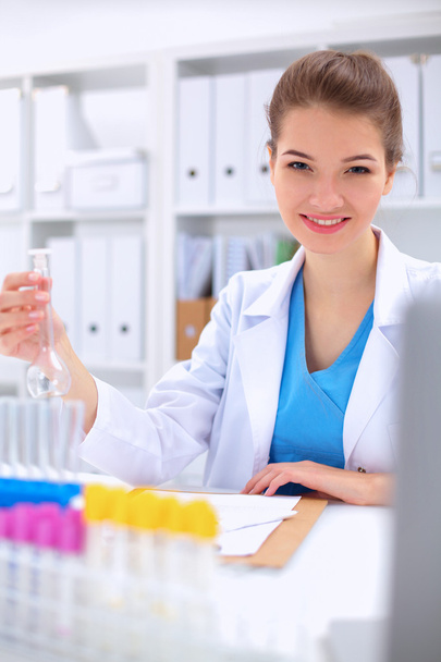 Woman researcher is surrounded by medical vials and flasks, isolated on white background - Φωτογραφία, εικόνα